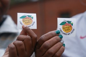 Voters hold up their stickers