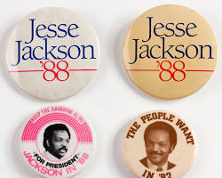 An authentic, vintage 1988 Jesse Jackson for President campaign button featuring bold typography and the iconic colors of the Rainbow Coalition movement.